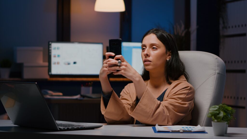 Person surrounded by phone notifications and work emails feeling mentally exhausted