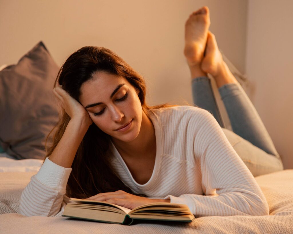 Person enjoying a peaceful evening routine with reading, journaling, and soft lighting before bedtime