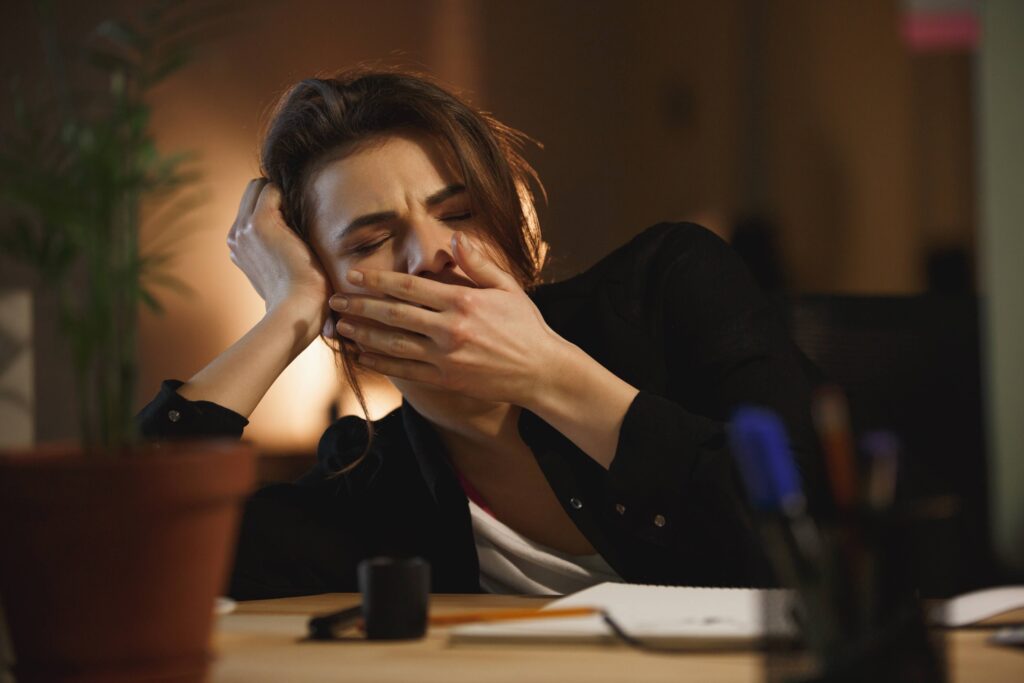 Person looking mentally overwhelmed at work after a poor night's sleep while everyday tasks feel unusually stressful