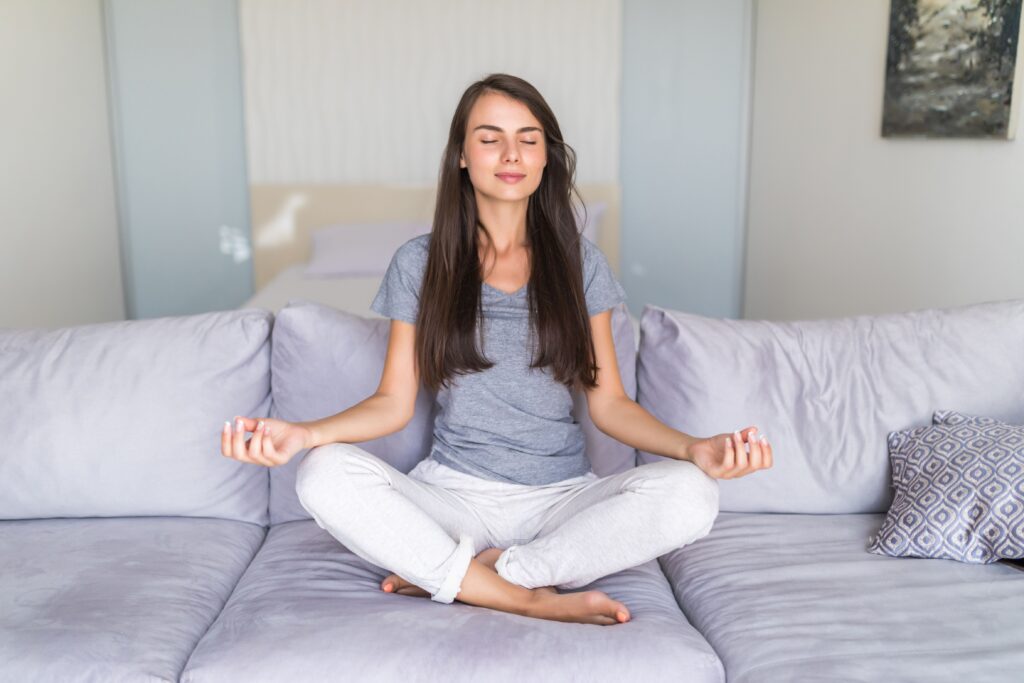 Person practicing slow breathing while sitting peacefully near a window