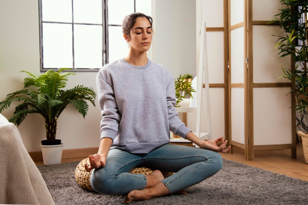 Person sitting comfortably in a quiet room practicing slow breathing exercises during the evening