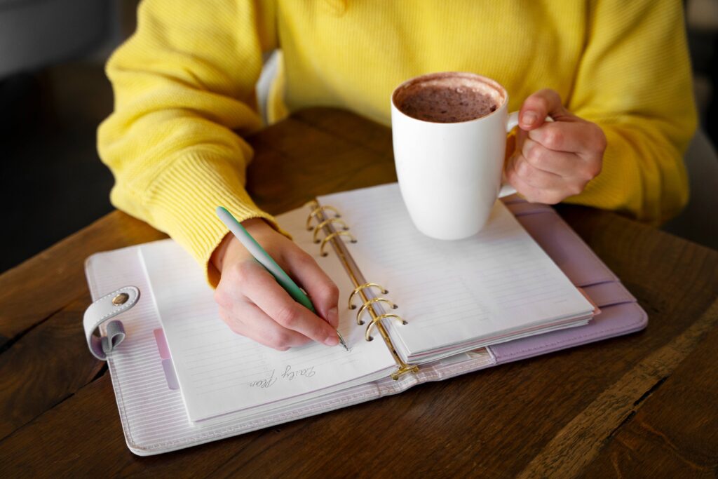 Notebook with tomorrow's task list beside a cup of tea during an evening planning session