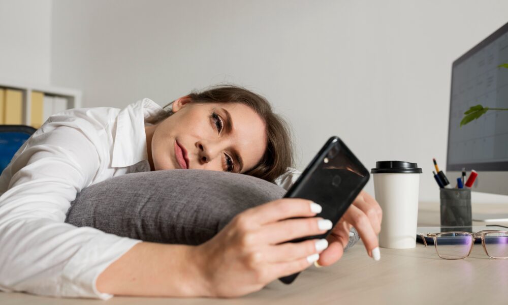 Woman feeling mentally tired after scrolling on her smartphone