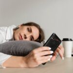 Woman feeling mentally tired after scrolling on her smartphone