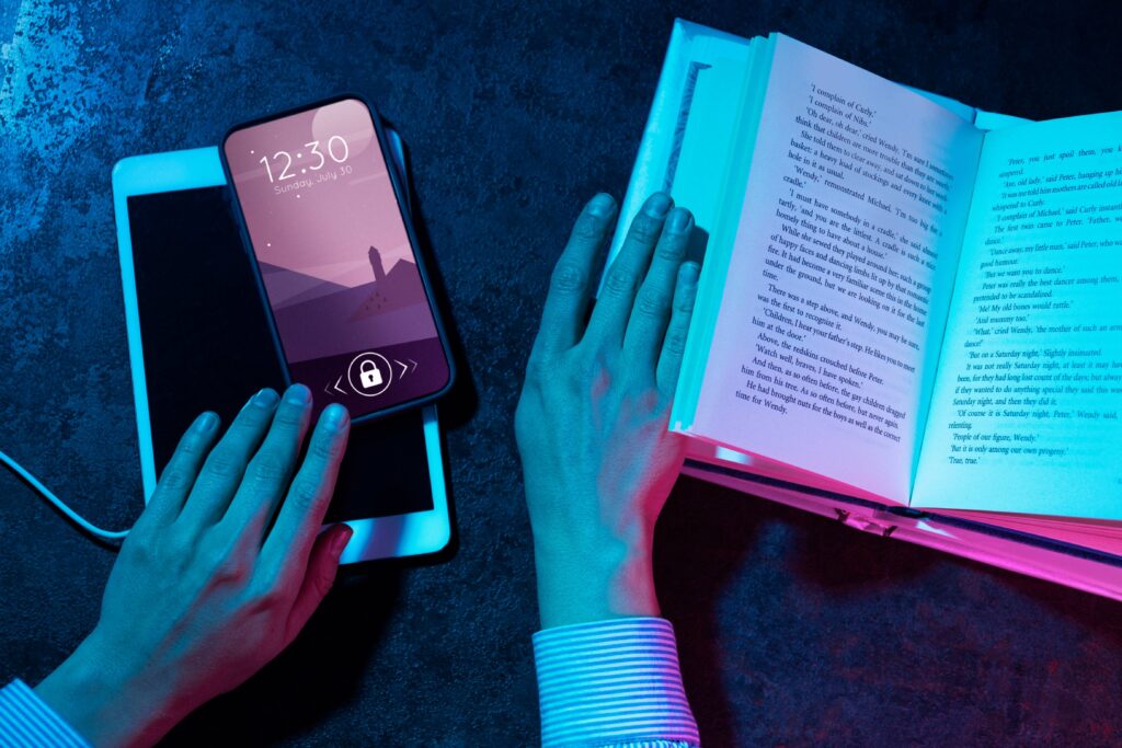 Close-up of a smartphone lighting up with notifications while someone is reading a book at a desk