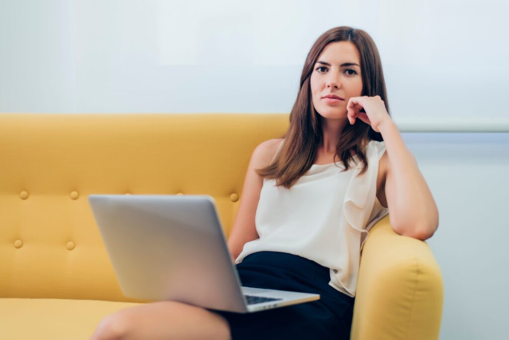 Professional sitting at home while thinking about work instead of enjoying free time