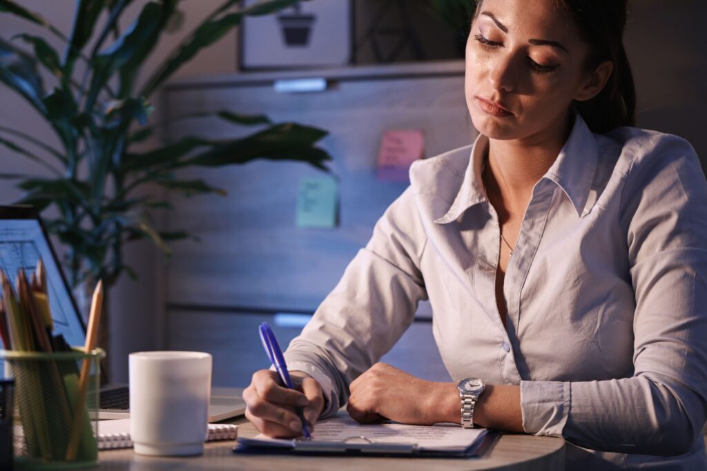 Person writing a simple to-do list while focusing on one task at a time