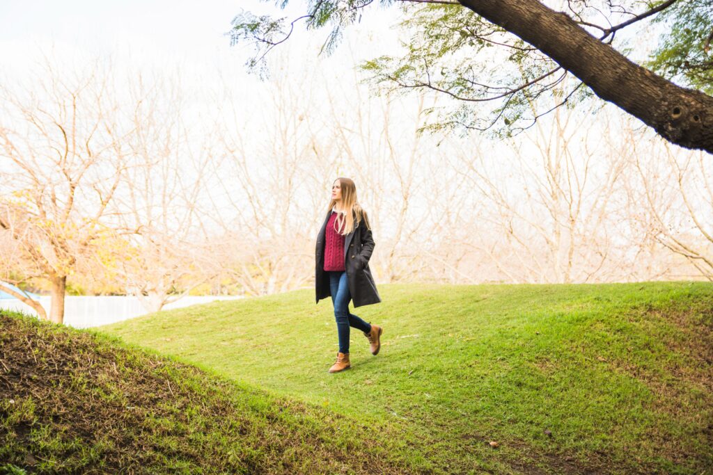 Person walking outdoors in a quiet park to reduce stress and clear their mind