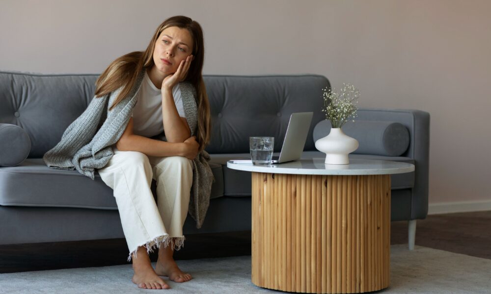 Person sitting comfortably at home while looking mentally tense despite having no urgent responsibilities