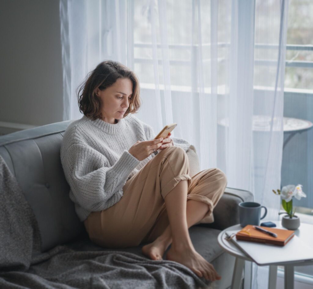 Woman thoughtfully rereading a message on her phone